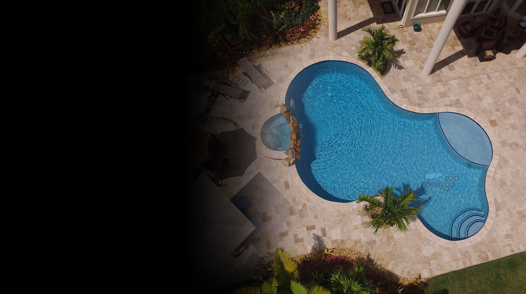 Freeform pool surrounded by tropical landscaping